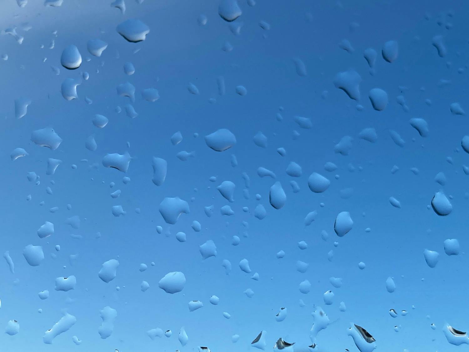 draaber paa rude Dråper på vindu med himmelen som bakgrunn